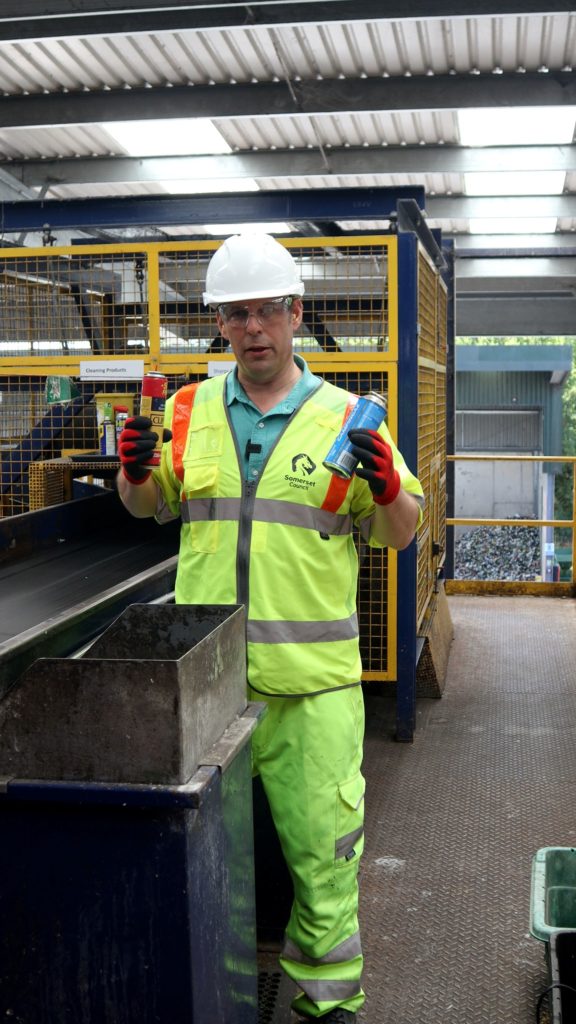 Councillor Richard Wilkins shows gas canisters at a recycling site