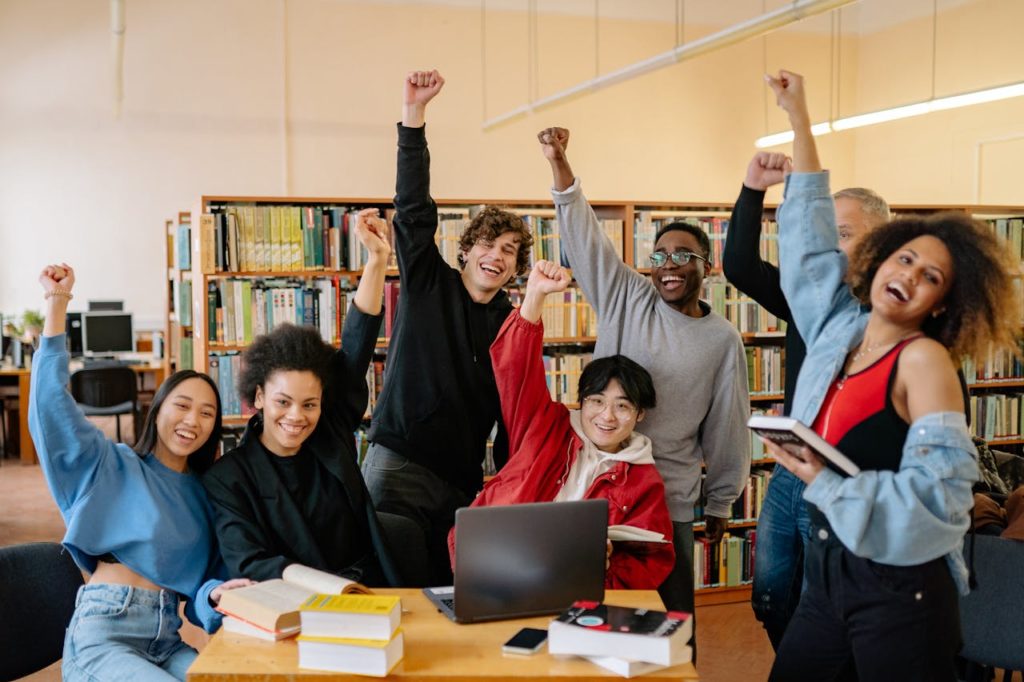 Stock image of a group of students giving high fives by Yan Krukau from Pexels.