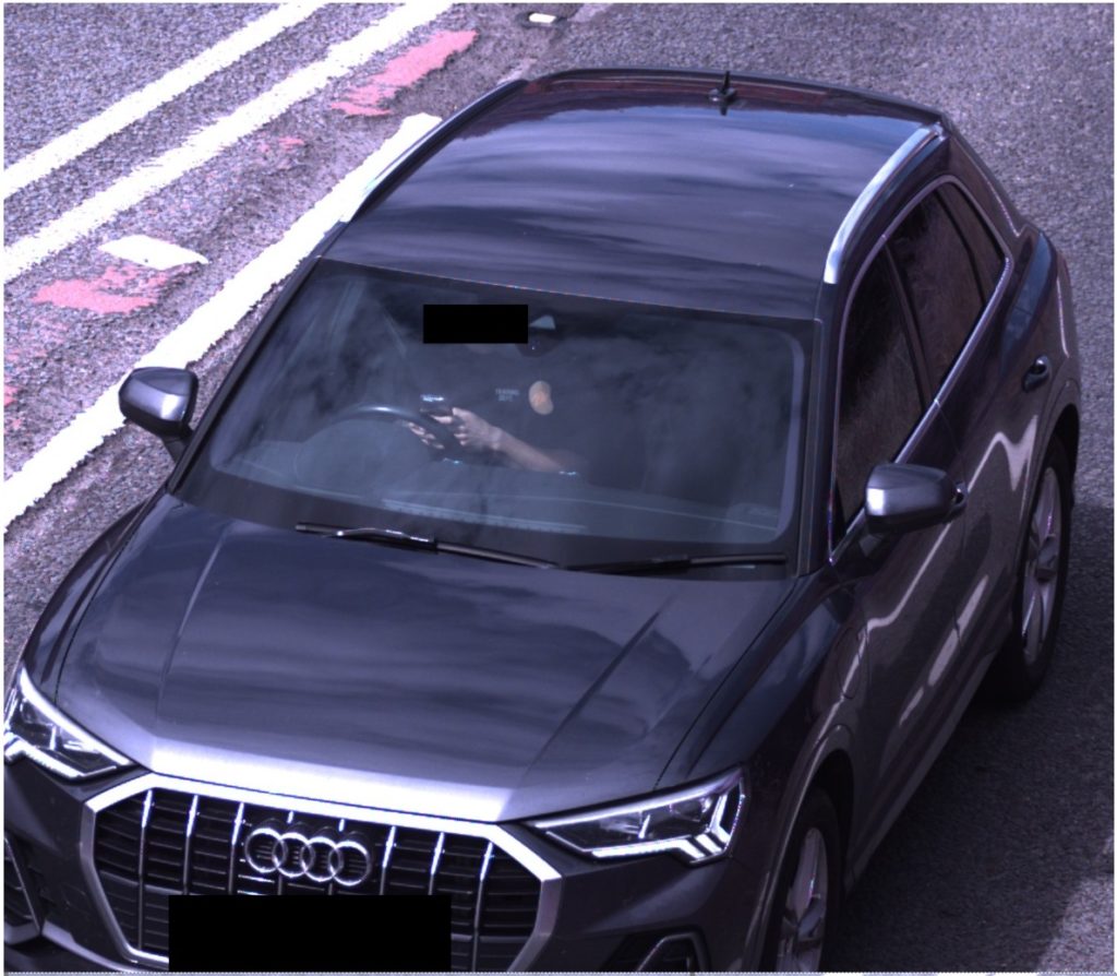 Image of a car driver using a mobile phone