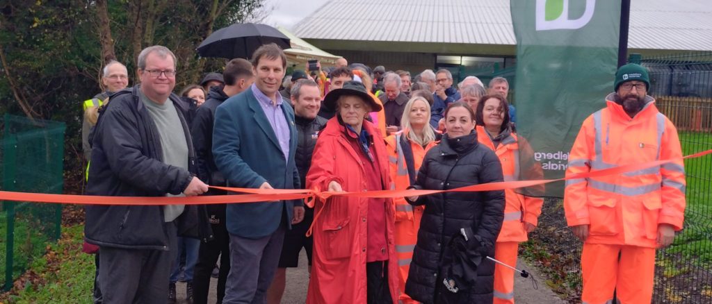 People watch as the tape is cut to mark the opening of a stretch of public path