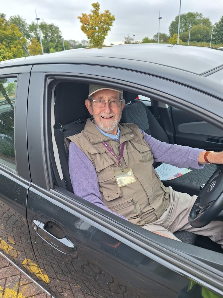 Man sat in car smiling