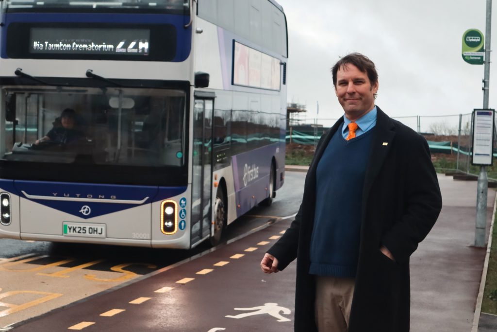 Councillor wits at the bus stop for a bus that is approaching