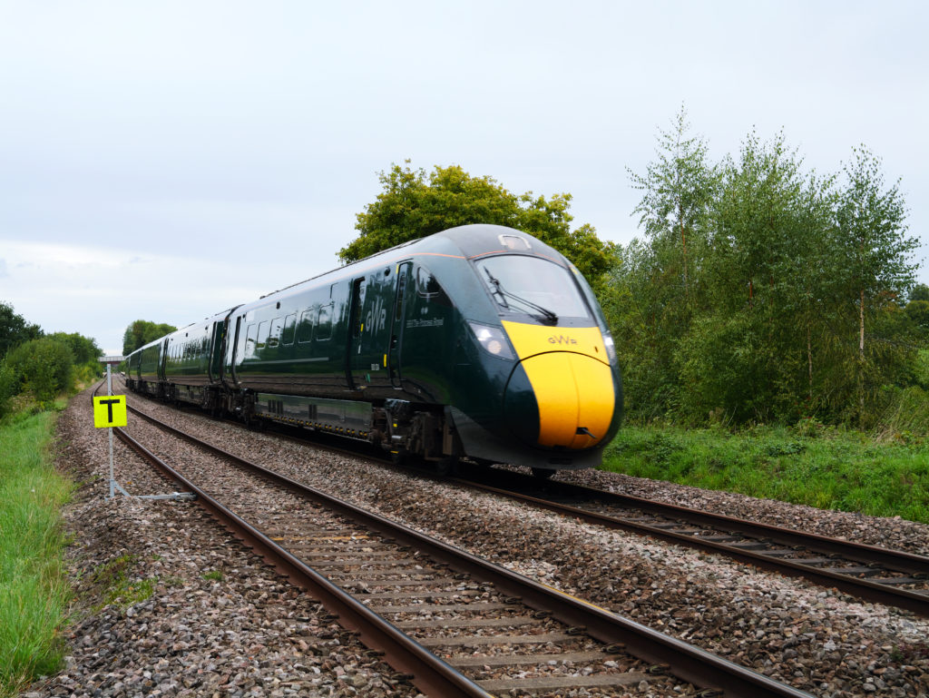 GWR Intercity Train through Rural Countryside running on tracks, green fields and trees beside the line in Somerset.