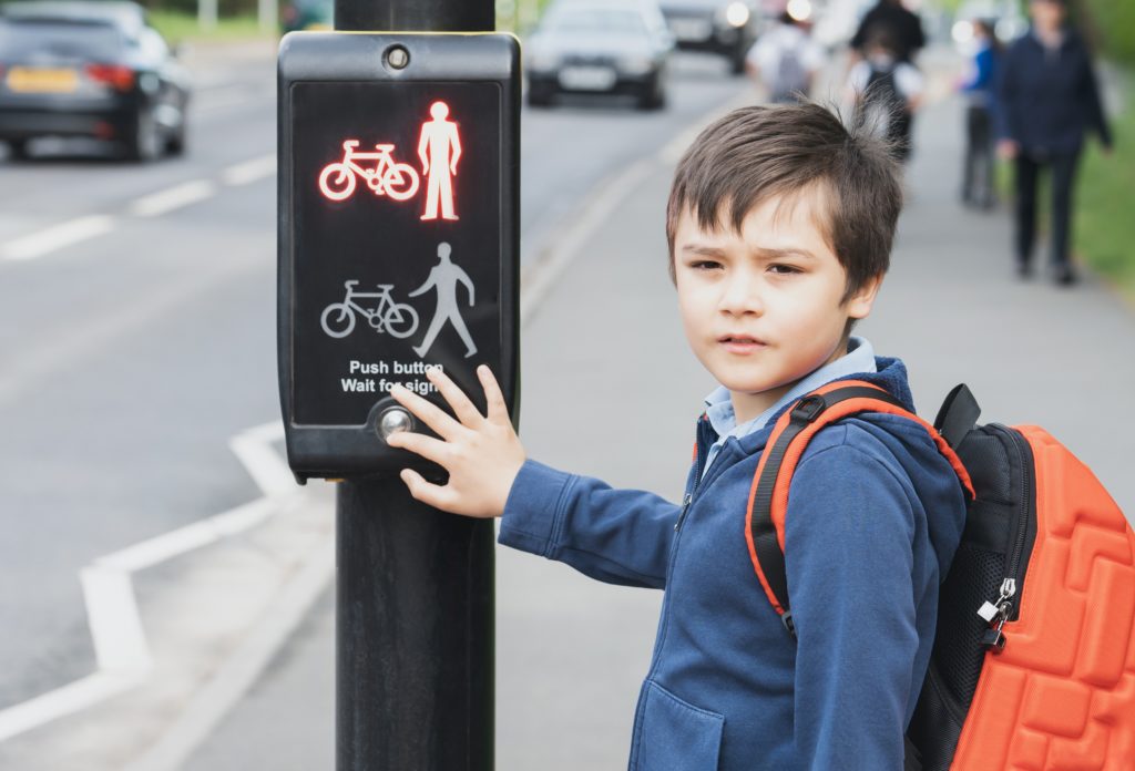 Child standing at toucan crossing