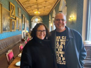 Two people, Col and Karen Needham stand in the Long Gallery at The Bishops Palace in Wells.