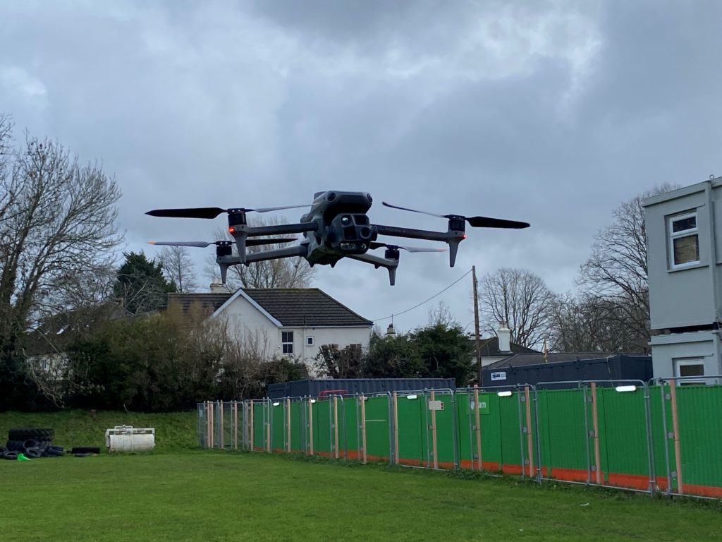 A drone hovering over grass.