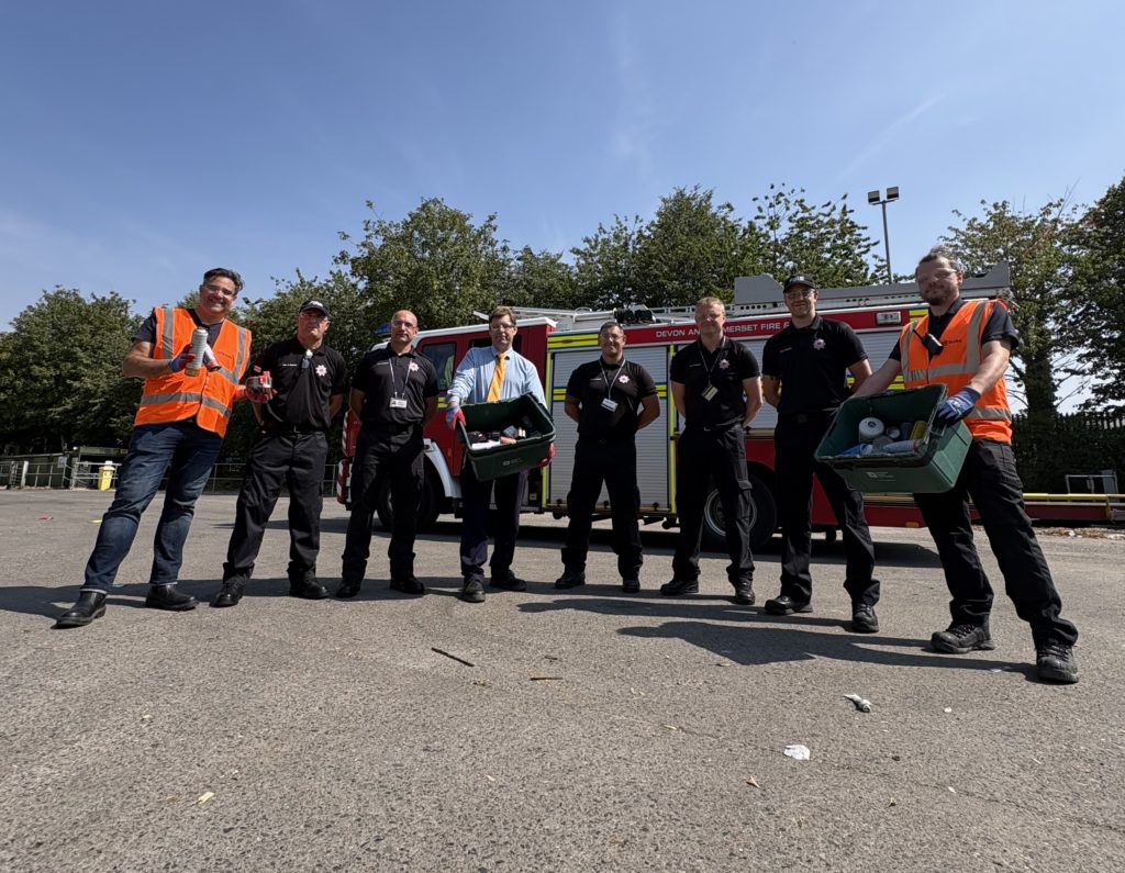 SUEZ recycling staff, fire service personnel and council representatives stand beside a fire engine promoting safe battery disposal.
