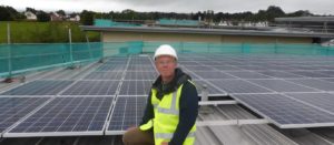 Workman standing in front of solar panels