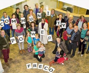 Group of people holding letters that spell out community power